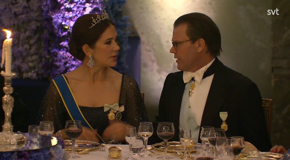 Mary de Dinamarca y Daniel de Suecia hablando en la cena por el Jubileo de Carlos Gustavo de Suecia