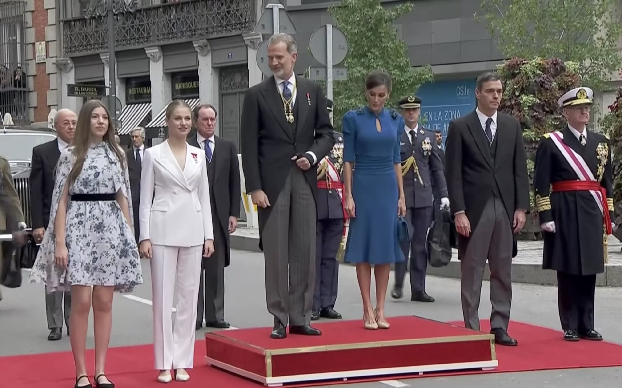 La Familia Real y Pedro Sánchez escuchan el Himno de España en la Carrera de San Jerónimo