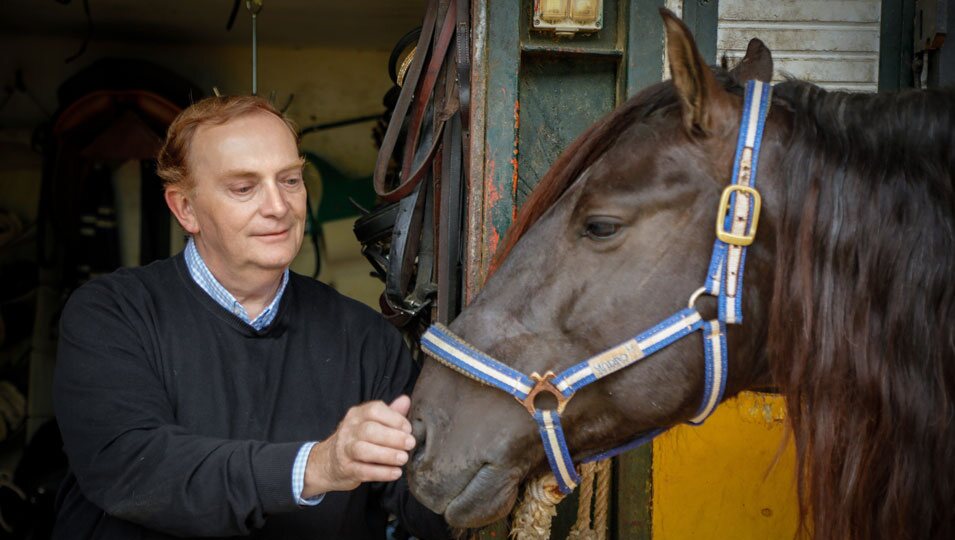 Gonzalo Giner acariciando a un caballo de la Yeguada Cartuja