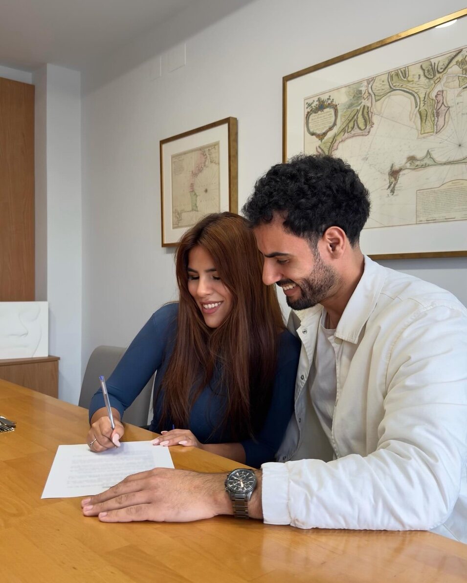 Isa y Asraf firmando | Instagram