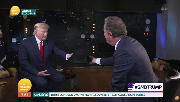 Momento en el que Piers Morgan le da el sombrero a Donald Trump