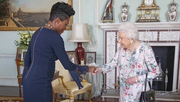 Encuentro de la Reina con Lakisha Grant en la que se ven las fotos de familia