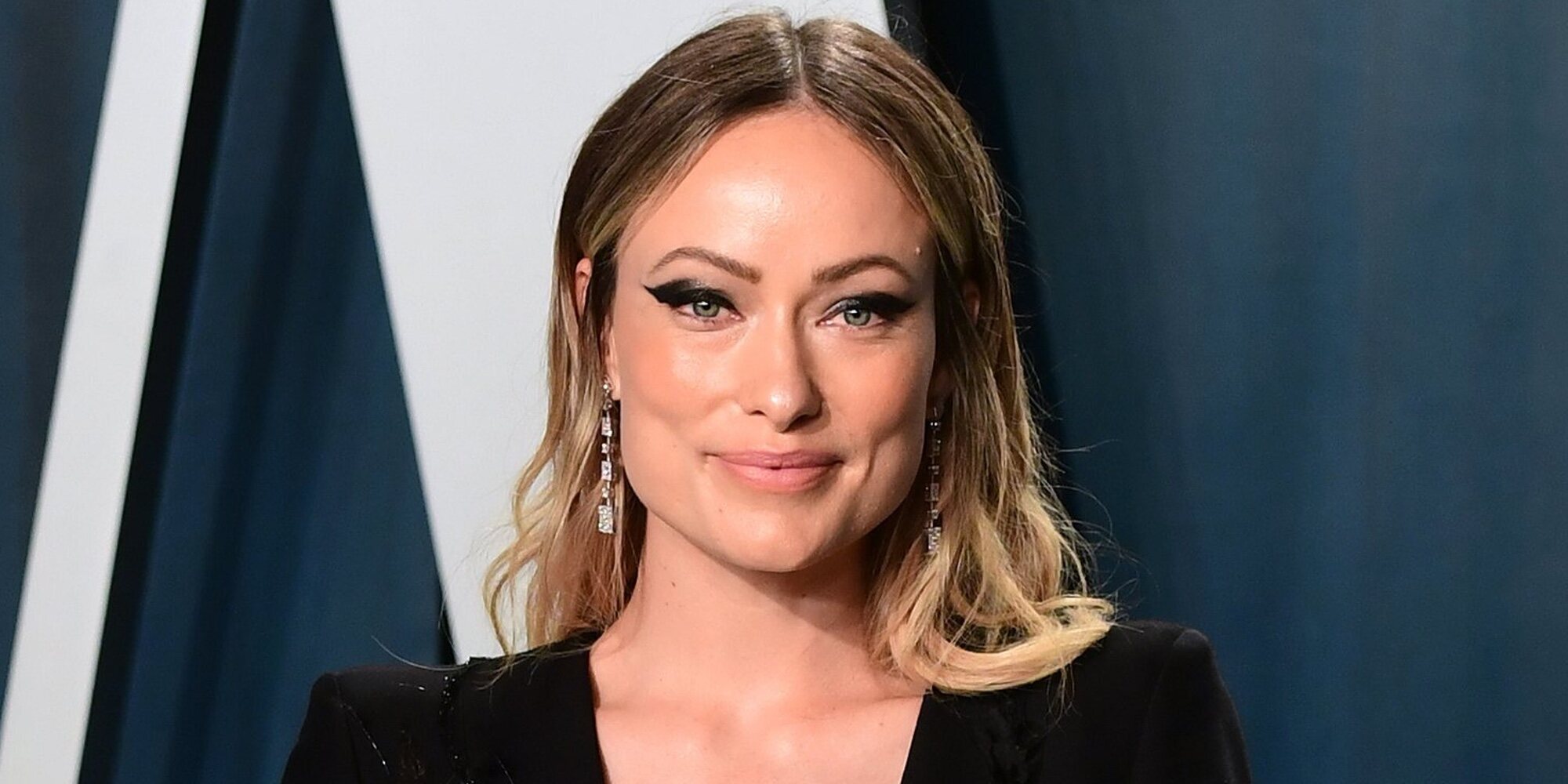 Olivia Wilde recibe unos documentos legales de Jason Sudeikis durante la presentación de su última película