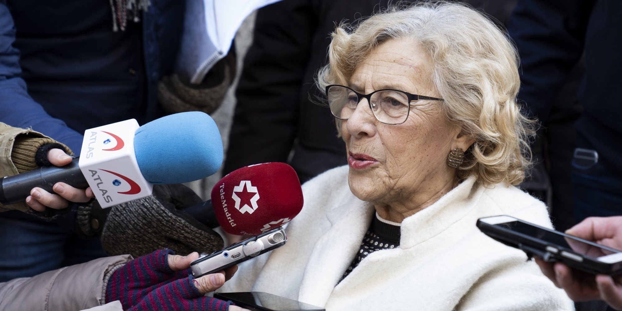 Manuela Carmena recibe el alta y reaparece en silla de ruedas tras ser operada de un pie