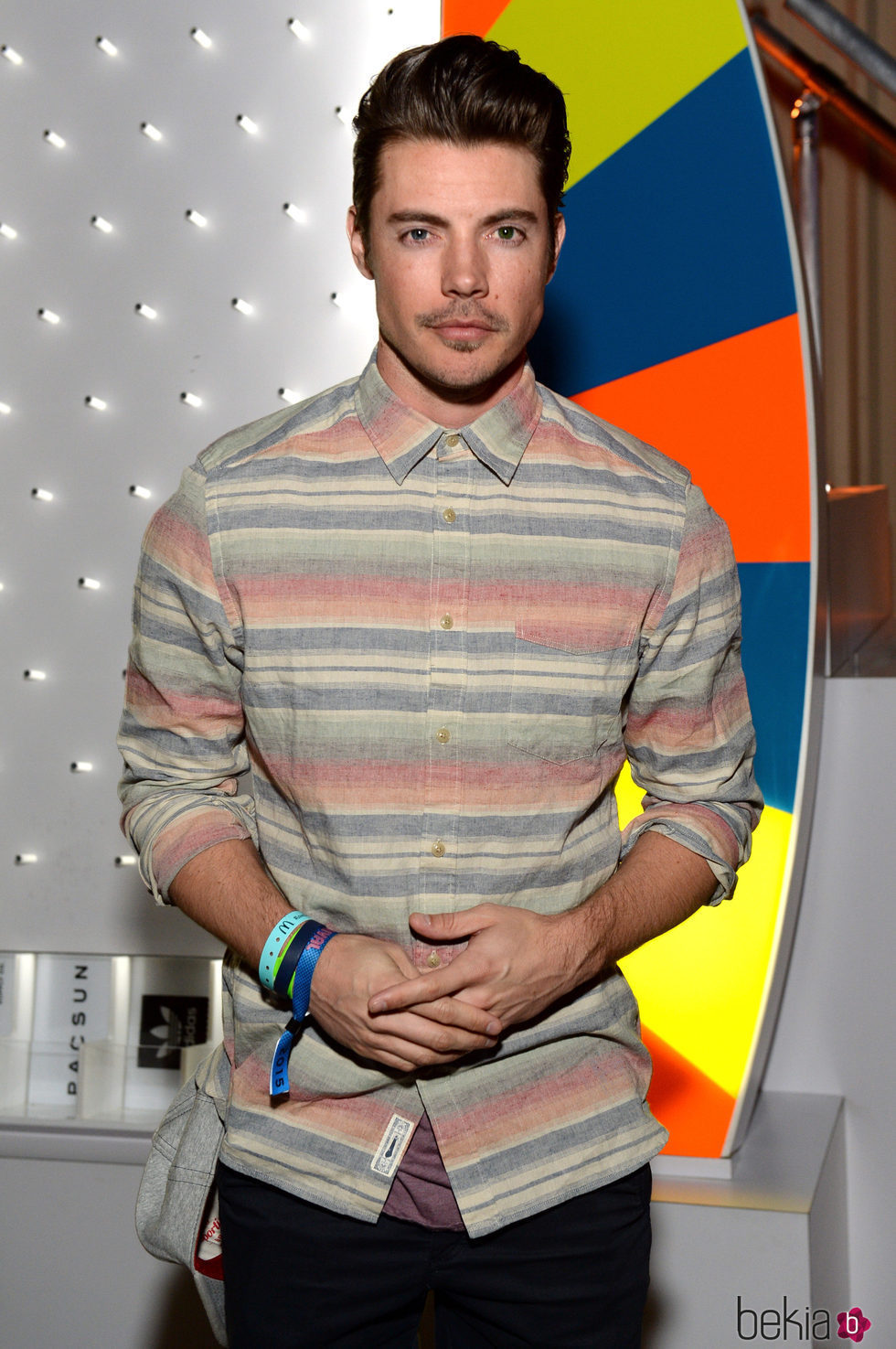 El actor Josh Henderson sobre un fondo colorido en una presentación