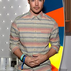 El actor Josh Henderson sobre un fondo colorido en una presentación