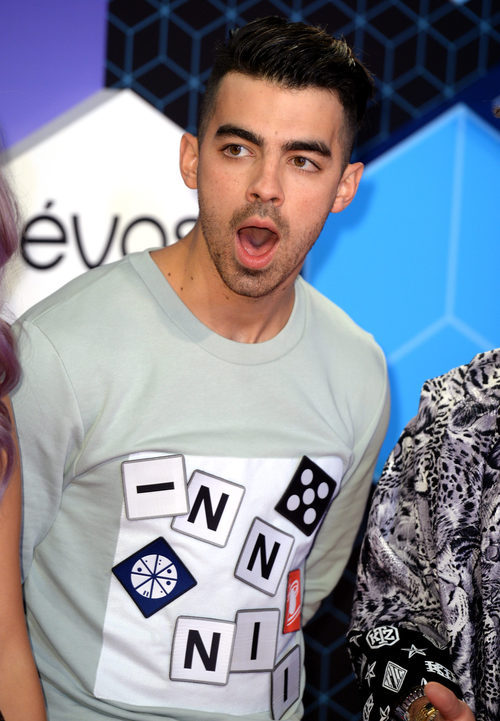 Joe Jonas abriendo la boca mientras posaba en la alfombra roja de los MTV EMA 2016