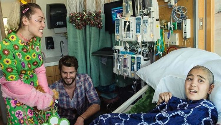 Miley Cyrus y Liam Hemsworth junto a una enferma en el hospital infantil