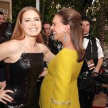 Amy Adams y Natalie Portman saludándose en la alfombra roja de los Globos de Oro 2017