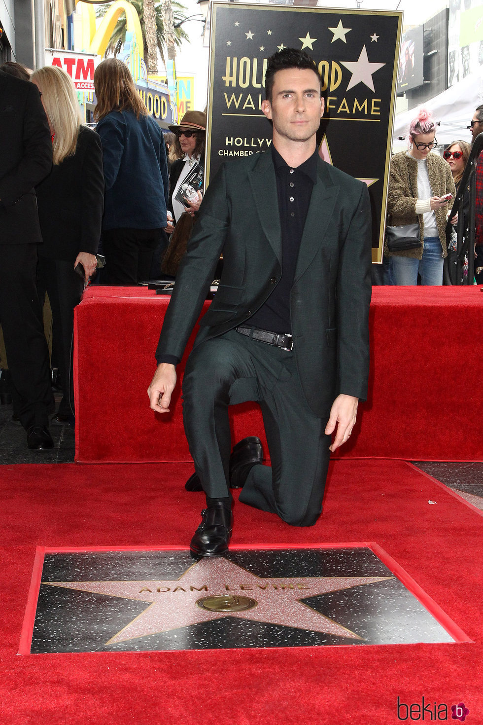 Adam Levine posando con su estrella en el Paseo de la Fama