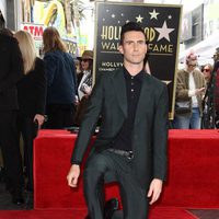 Adam Levine posando con su estrella en el Paseo de la Fama