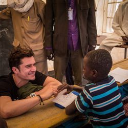 Orlando Bloom sonríe a un niño en un campamento de Unicef