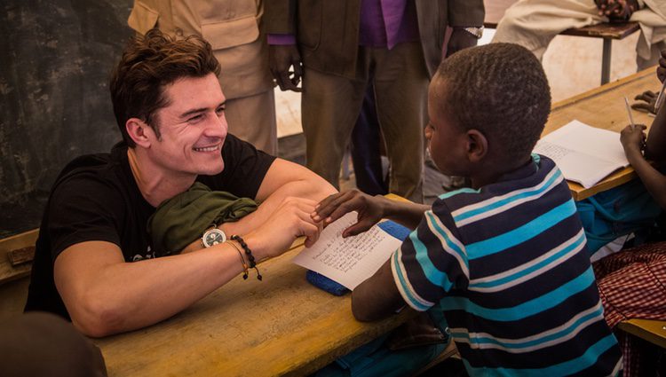 Orlando Bloom sonríe a un niño en un campamento de Unicef