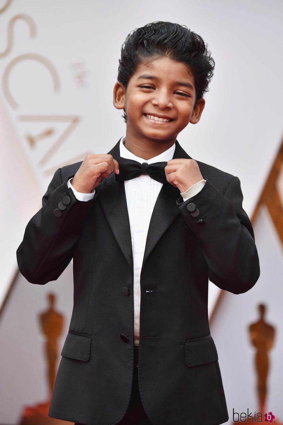 Sunny Pawar colocándose la pajarita en la alfombra roja de los Premios Oscar 2017