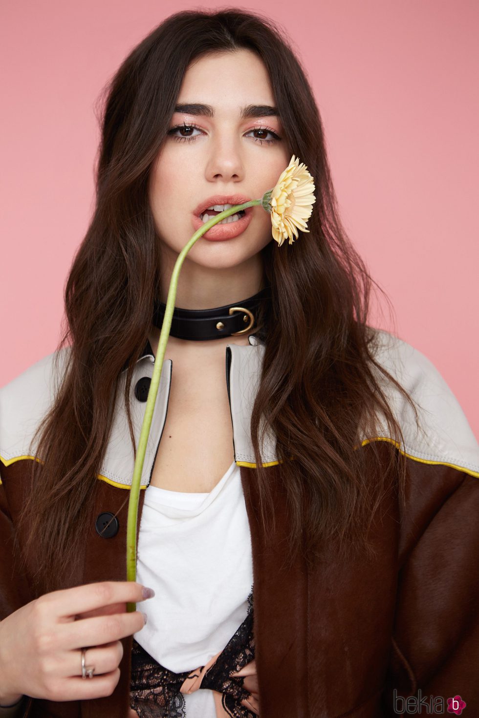 Dua Lipa posando con una flor en la boca