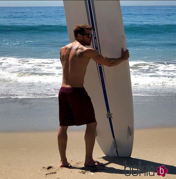 Ryan Phillippe sostiene una tabla de surf