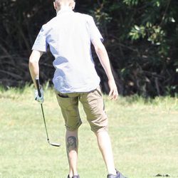 Justin Bieber jugando a golf y enseñando su tatuaje de Cristo