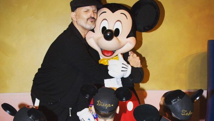 Miguel Bosé abrazando a Mickey Mouse con sus cuatro hijos