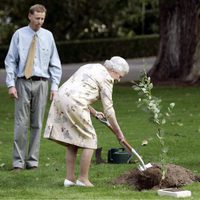 La Reina Isabel planta un árbol mientras el Duque de Edimburgo le observa