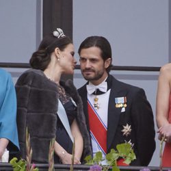 Sofia Hellqvist habla al oído a Carlos Felipe de Suecia en el 80 cumpleaños de Harald y Sonia de Noruega