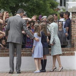 Los Reyes Felipe y Letizia y sus hijas saludan a unas señoras en la Comunión de la Infanta Sofía