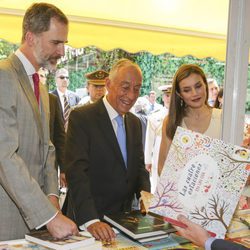 Los Reyes Felipe y Letizia con el presidente de Portugal mirando libros en la inauguración de la Feria del Libro 2017