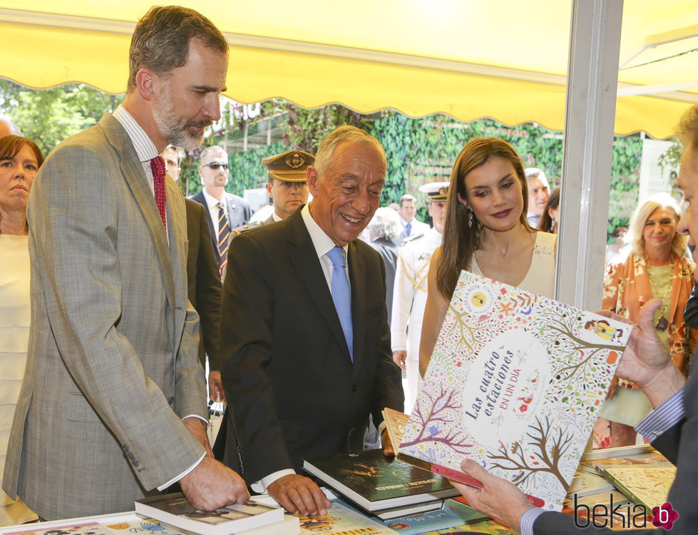 Los Reyes Felipe y Letizia con el presidente de Portugal mirando libros en la inauguración de la Feria del Libro 2017