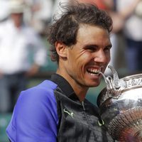 Rafa Nadal mordiendo el trofeo de campeón de Roland Garros 2017