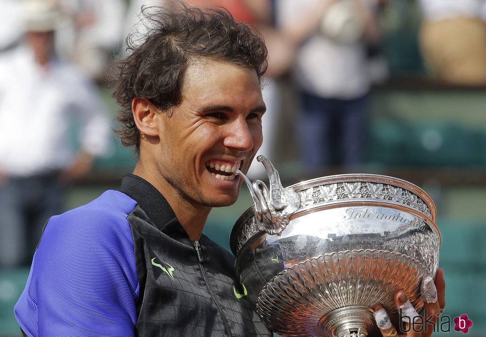 Rafa Nadal mordiendo el trofeo de campeón de Roland Garros 2017