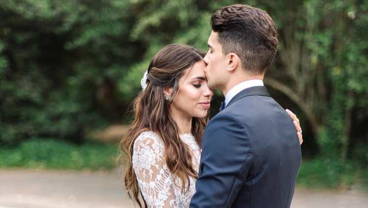 Marc Bartra besando en la frente a Melissa Jiménez en su boda