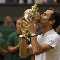 Roger Federer besando su premio tras ganar Wimbledon 2017