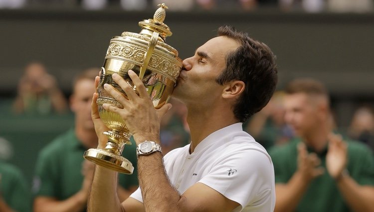 Roger Federer besando su premio tras ganar Wimbledon 2017