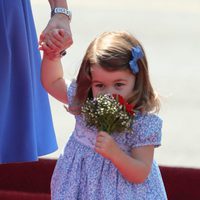 La Princesa Carlota huele unas flores a su llegada a Alemania