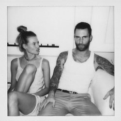 Adam Levine y Behati Prinsloo sentados por su tercer aniversario