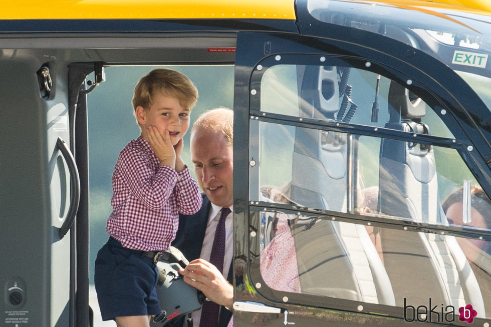 El Príncipe Jorge explorando un helicóptero en Hamburgo bajo la atenta mirada de Guillermo de Inglaterra