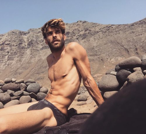 Jon Kortajarena luciendo cuerpo mientras descansa en una montaña rocosa