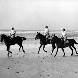 La Reina Isabel y la Princesa Margarita montando a caballo en la playa de jóvenes