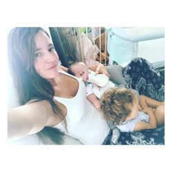 Malena Costa con su hija Matilda mientras da el biberón a su hijo Mario