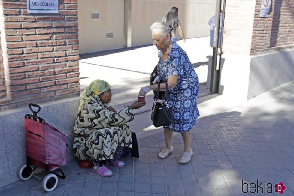 La madre de Antonio Carmona da limosna a una mujer tras visitar a su hijo en el hospital