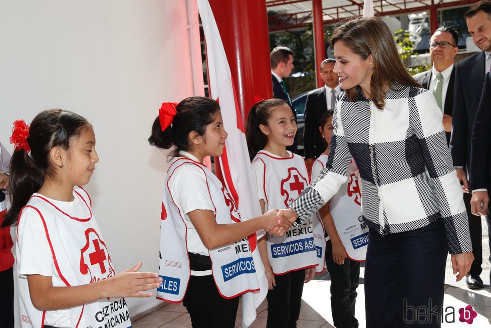 La Reina Letizia saluda a unas niñas durante su visita a la Sede Nacional de la Cruz Roja de México