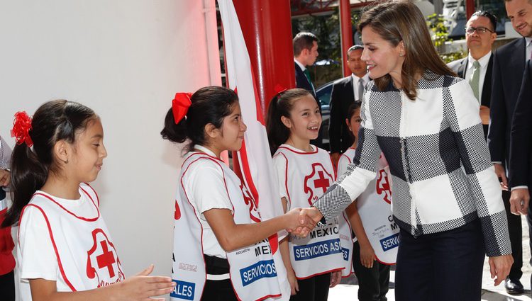 La Reina Letizia saluda a unas niñas durante su visita a la Sede Nacional de la Cruz Roja de México