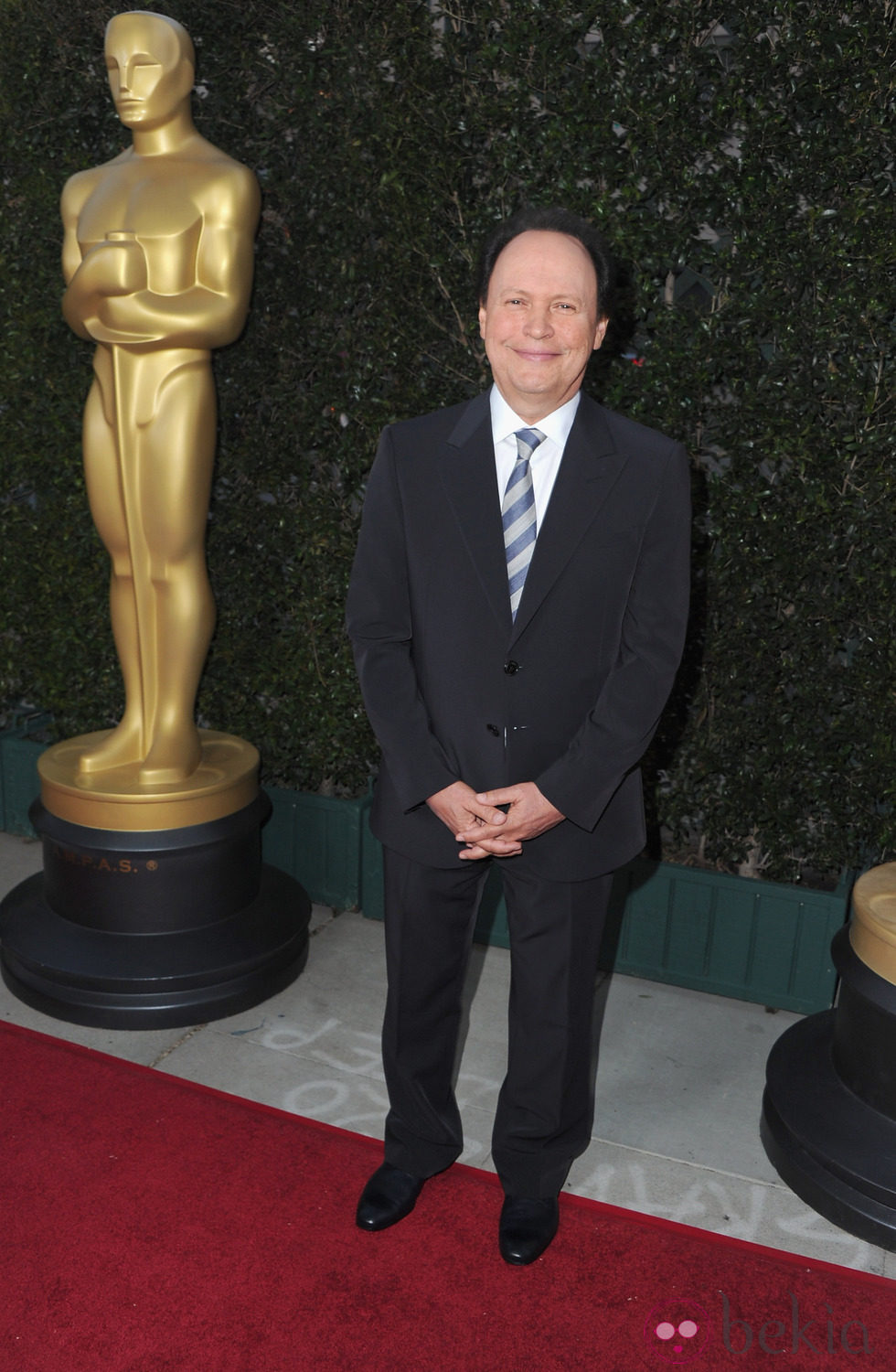 Billy Crystal junto a la estatua de los Oscar