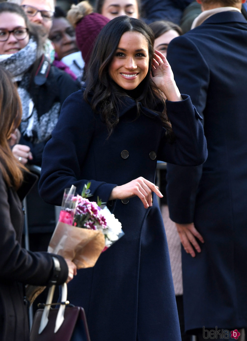 Meghan Markle sonriente en su primer acto público tras el compromiso con el Príncipe Harry