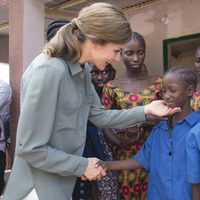 La Reina Letizia con un niño en la granja Naatangué de Senegal