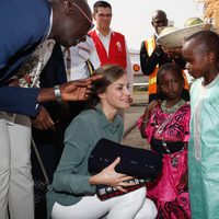 La Reina Letizia recibe unos regalos de unos niños en su despedida de Senegal