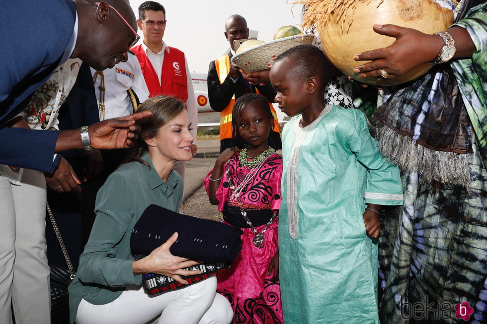 La Reina Letizia recibe unos regalos de unos niños en su despedida de Senegal