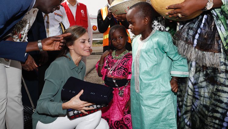 La Reina Letizia recibe unos regalos de unos niños en su despedida de Senegal