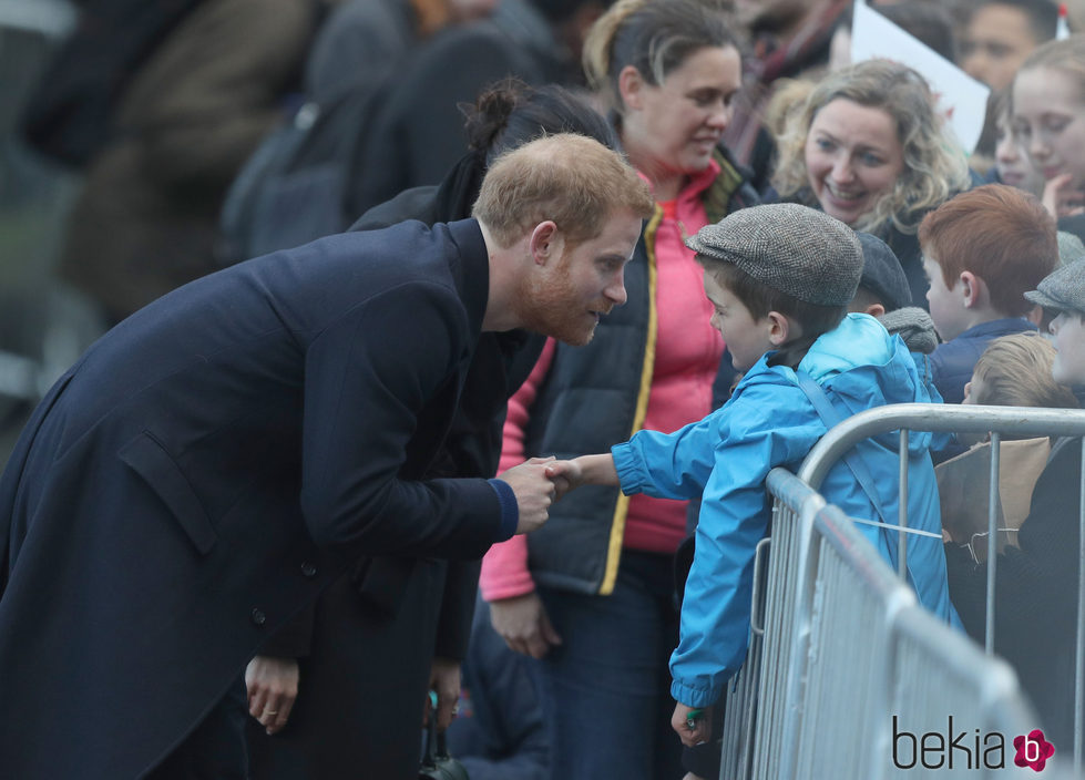 El Príncipe Harry saluda a un niño durante su visita oficial a Gales con Meghan Markle