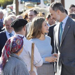 Los Reyes Felipe y Letizia dedicándose una confidencia en Poreñu