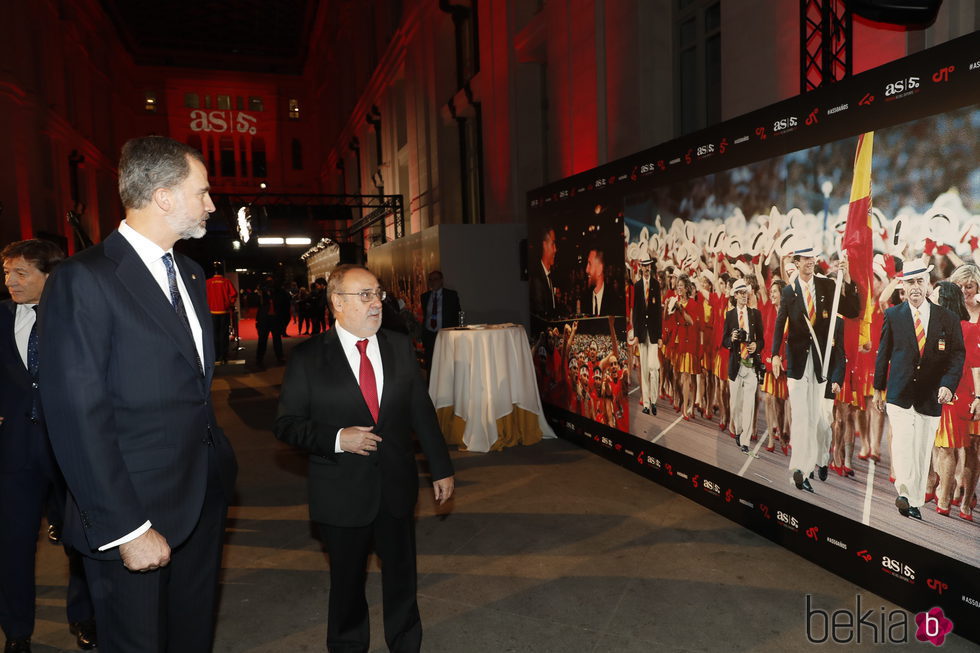 El Rey Felipe mirando una foto en la que aparece como abanderado español en Barcelona 92